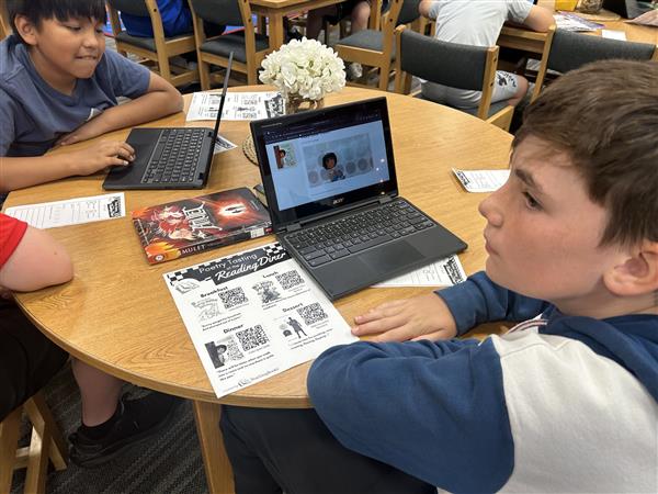  Students reading about poetry on laptop